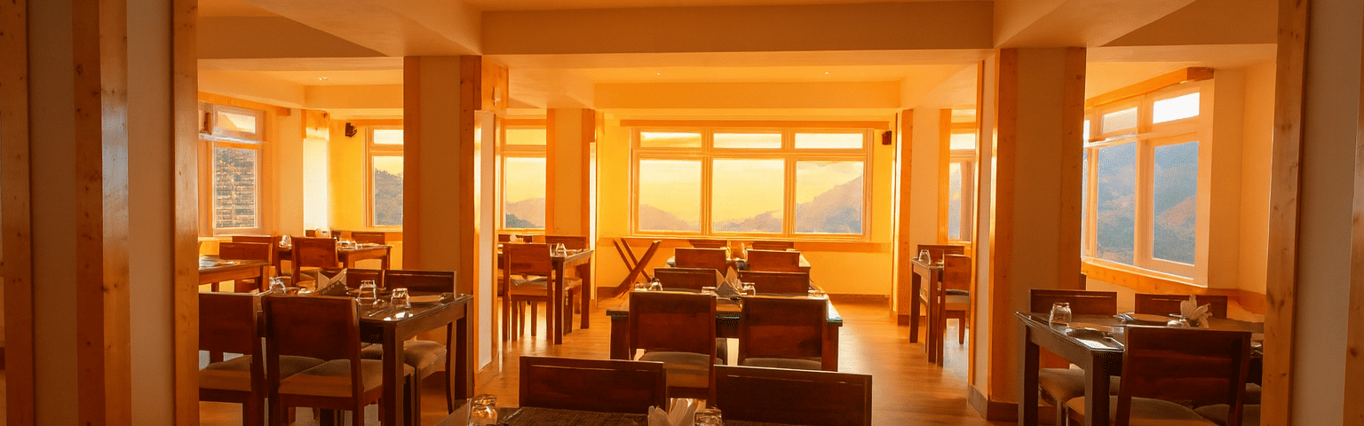 Fine dining restaurant in a Gangtok hotel featuring wooden interiors, mountain view windows, and premium seating for guests