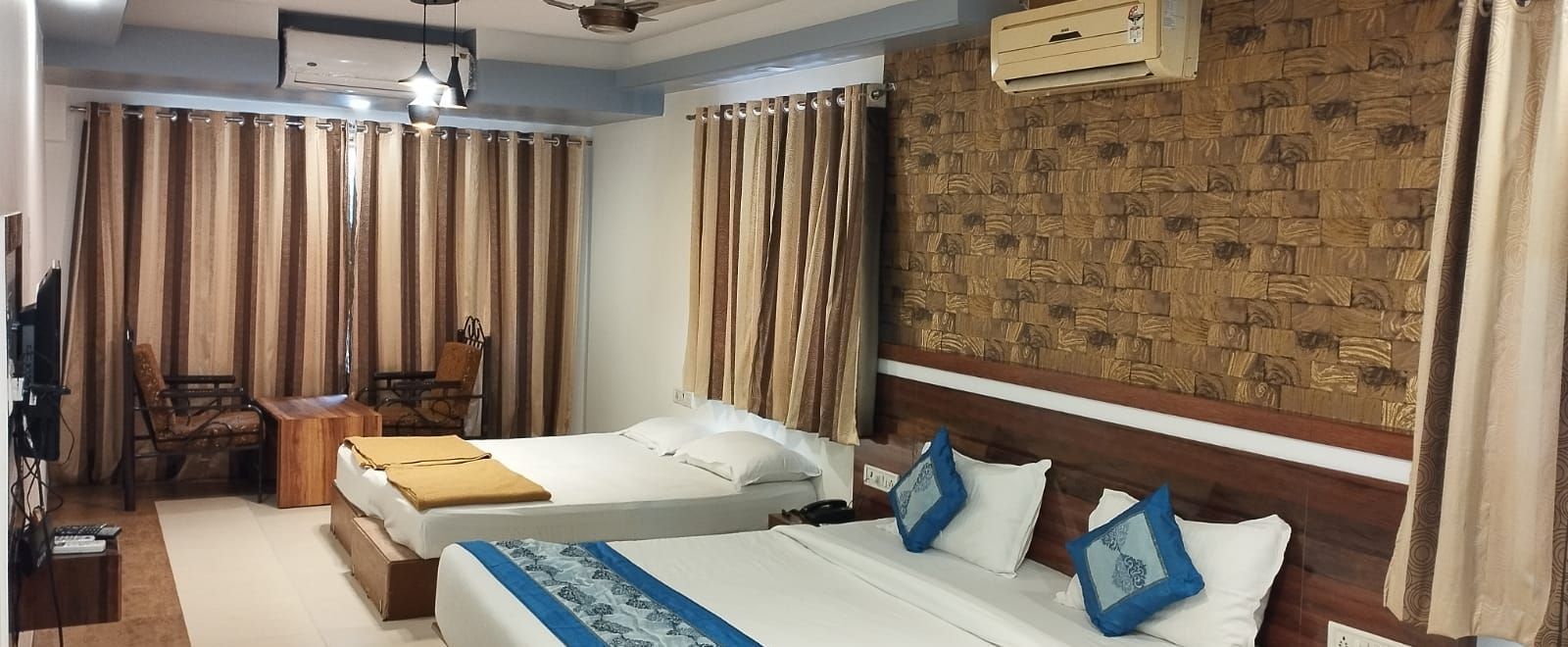 The Suite at Mountview Resort, furnished with two king size beds, drawn curtains, air-conditioning, and a seating area.