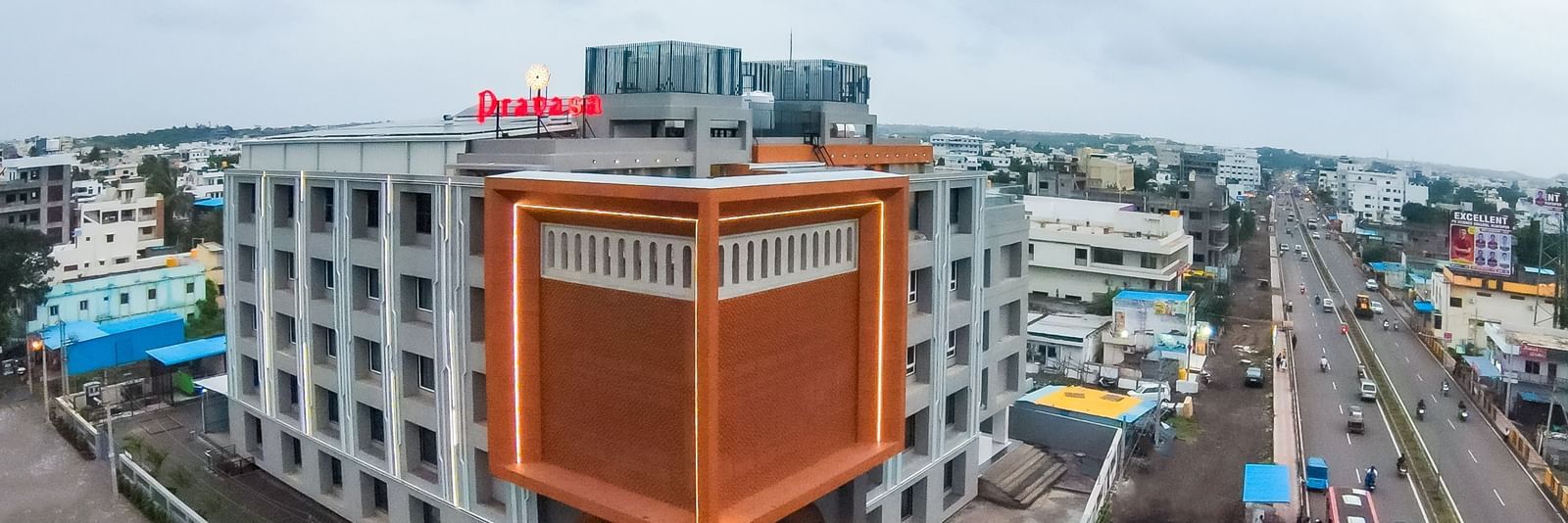 Building exterior of Pravasa Hotel from a distance with surrounding roads | Pravasa Hotel, Vijayapura