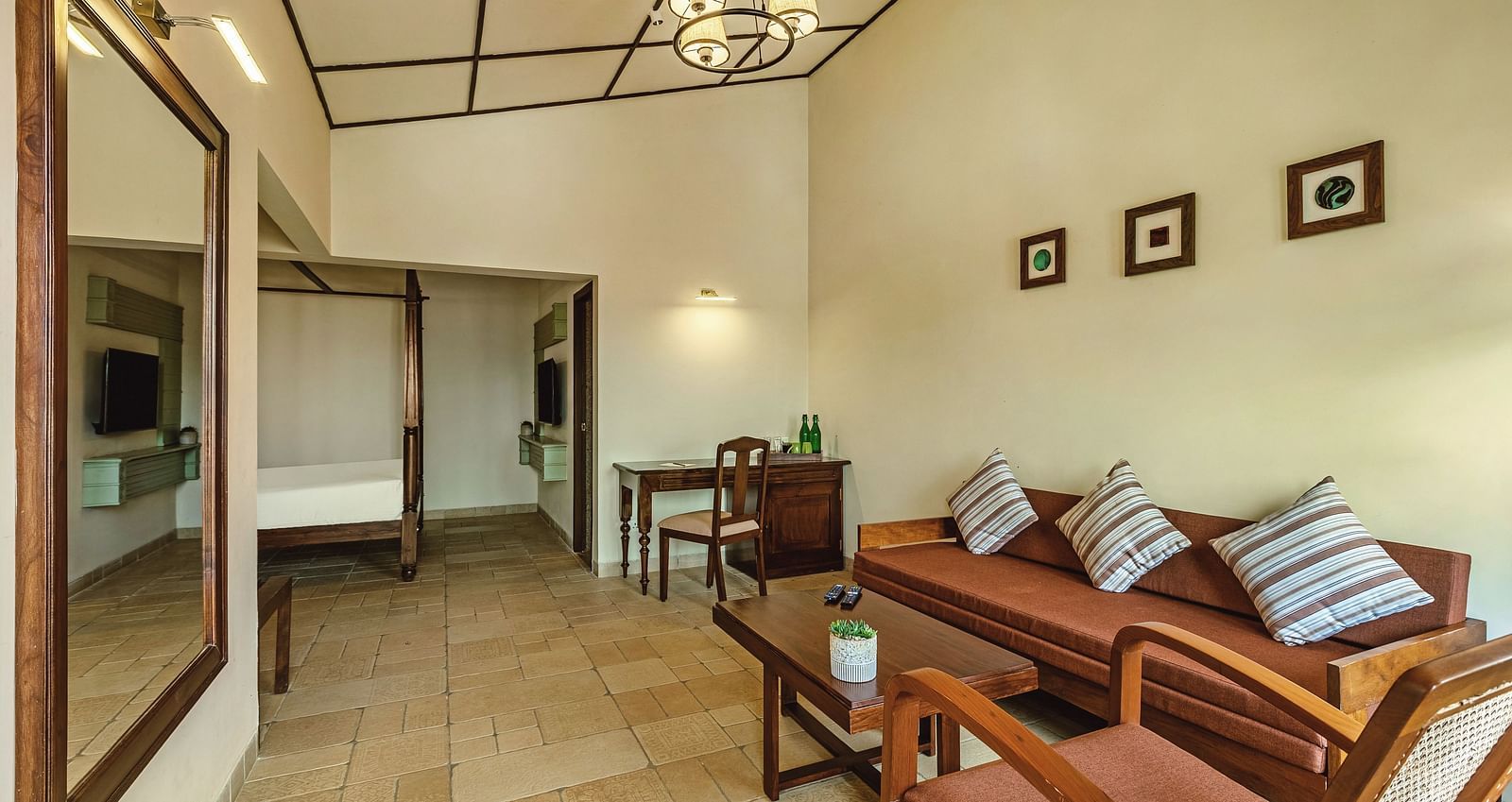 Spacious living area at Mango Hill Shola, Ooty featuring a stylish couch with patterned cushions, wall art, and soft ambient lighting.
