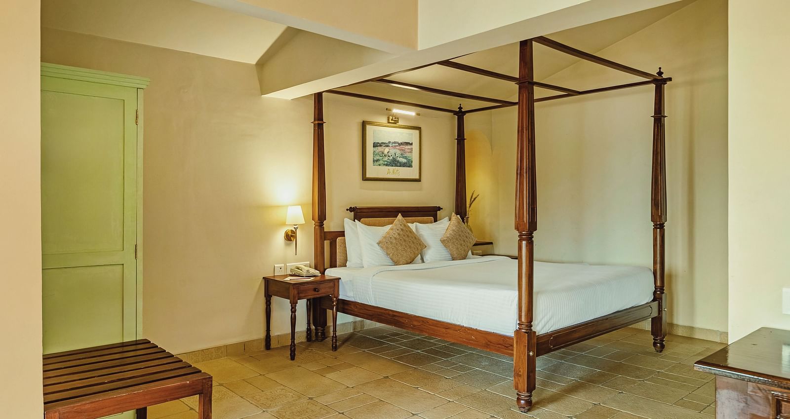 A bedroom at Mango Hill Shola, Ooty featuring a four-poster bed, wooden bench, and soothing lighting