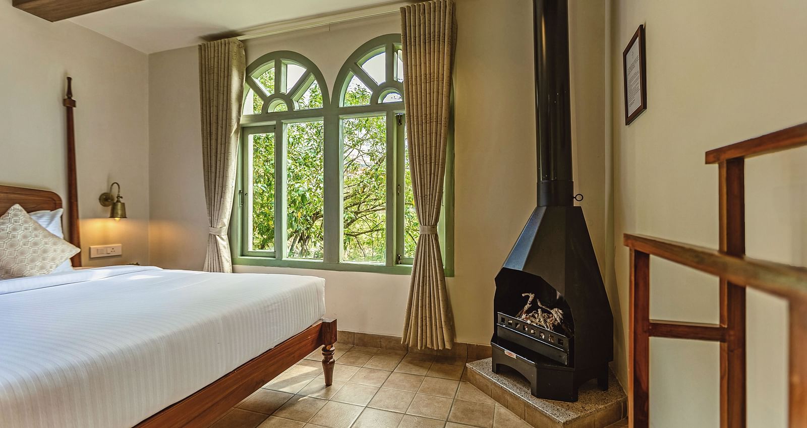 Junior Suite with Bathtub featuring a fireplace and serene views through tall windows at Mango Hill Shola, Ooty.