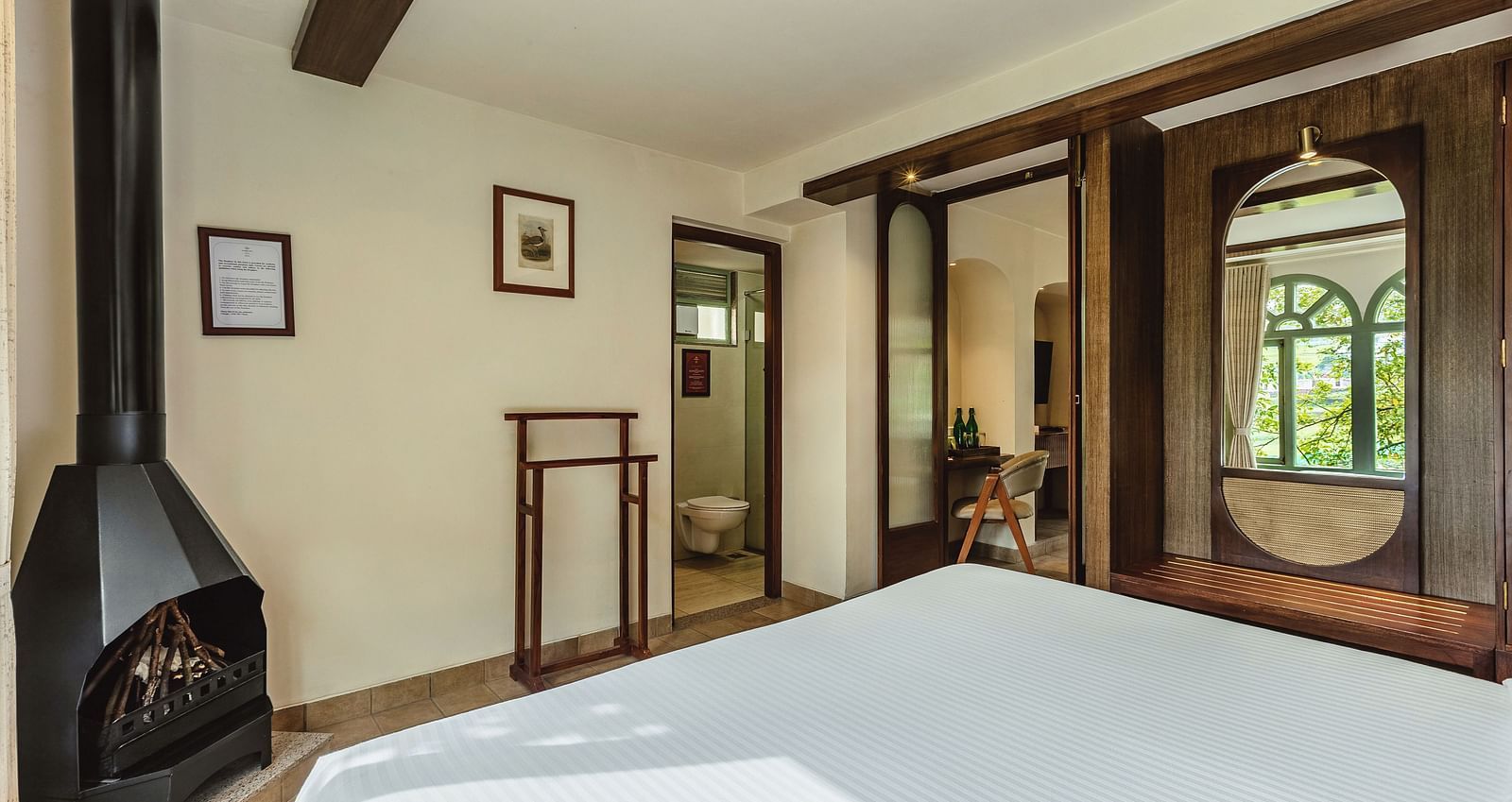 Junior suite with a canopy bed and a fireplace, offering a blend of rustic charm and modern comfort at Mango Hill Shola, Ooty.