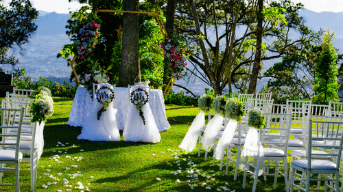 Wedding arrangements in the lawn area, featuring chairs and decorations arranged with a backdrop of mountains.