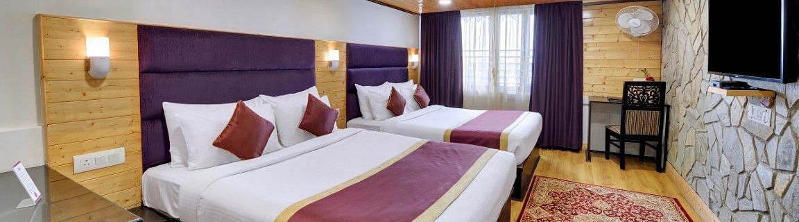 An image of a room with twin bed, flat screen TV, decorative lighting - Sumitel Darjeeling