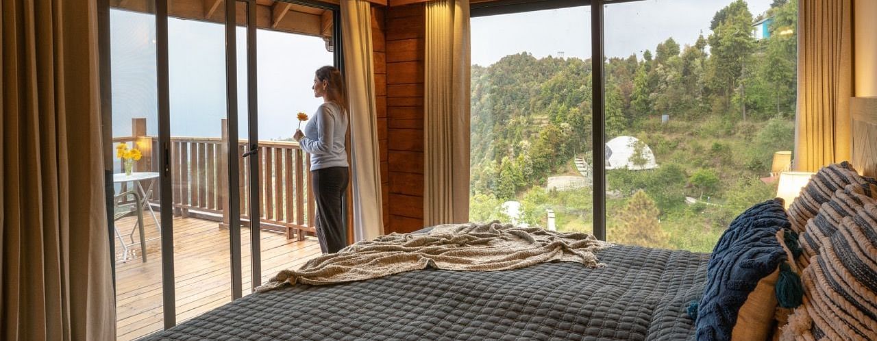 An image of a person staring at the view from a room at avalon cottages