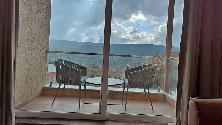 Balcony with seating overlooking green hills and surrounding scenery