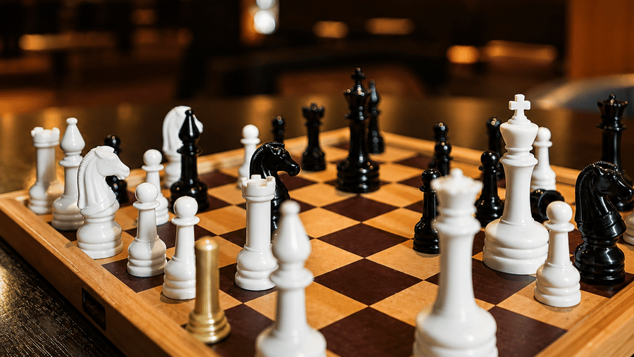 Wooden chessboard with chess pieces set up for a game in the lounge at Kiranshree Grand Hotel.