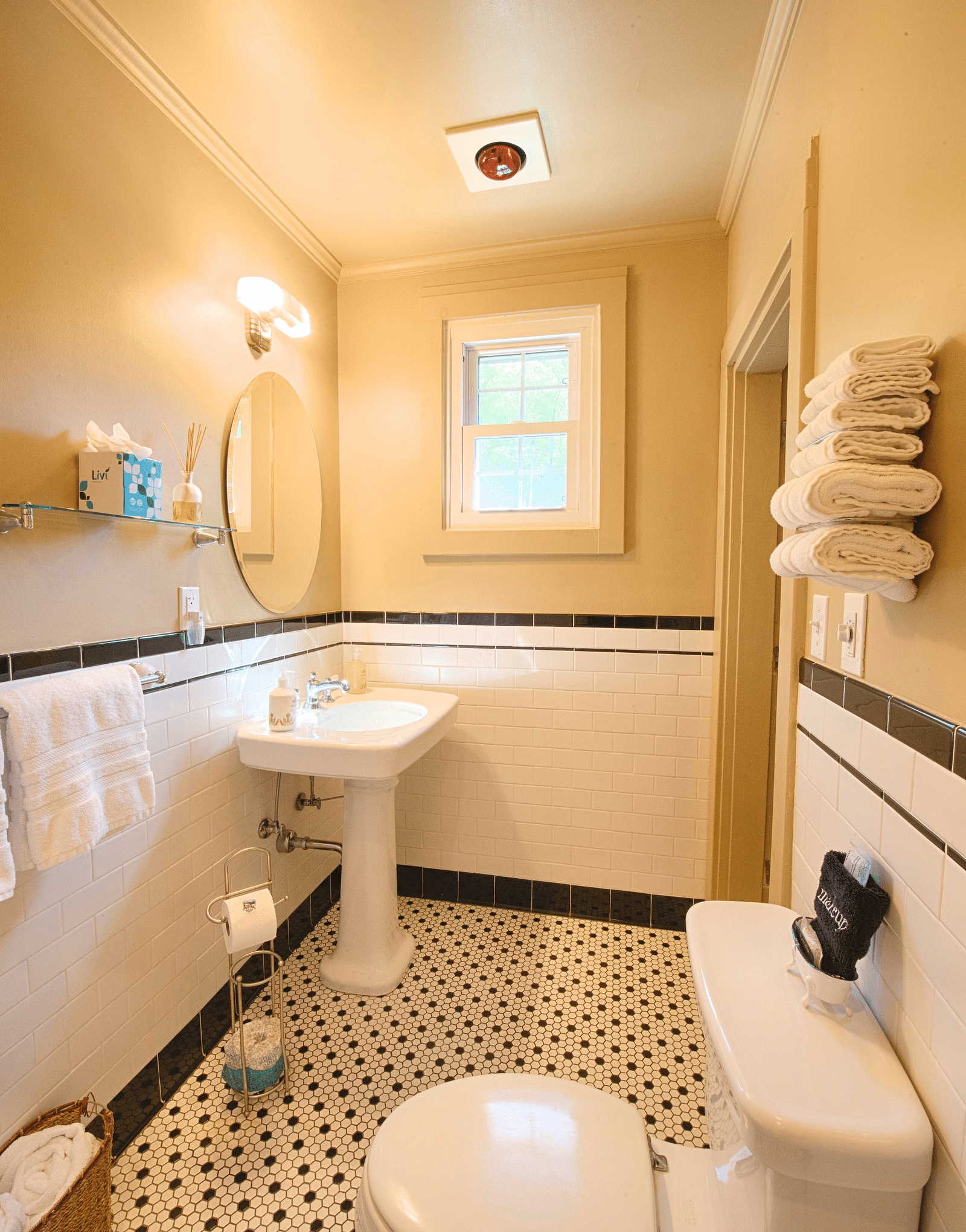 a bathroom with a commode and a wash basin alon with a wall mounted rack with folded towels - Historic Tapoco Lodge
