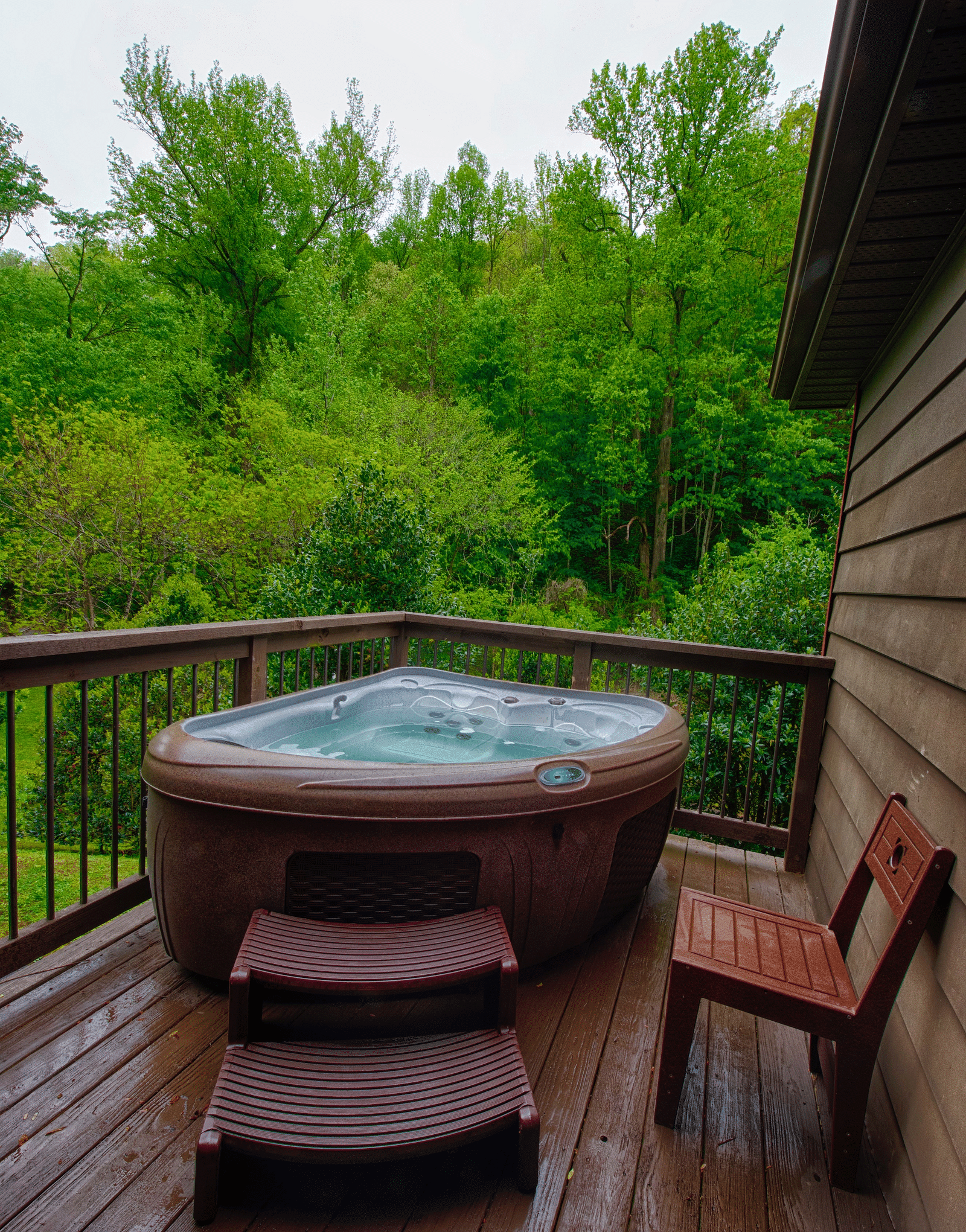 a private hot tub on a wooden porch surrounded by lush green views of the forests - Historic Tapoco Lodge