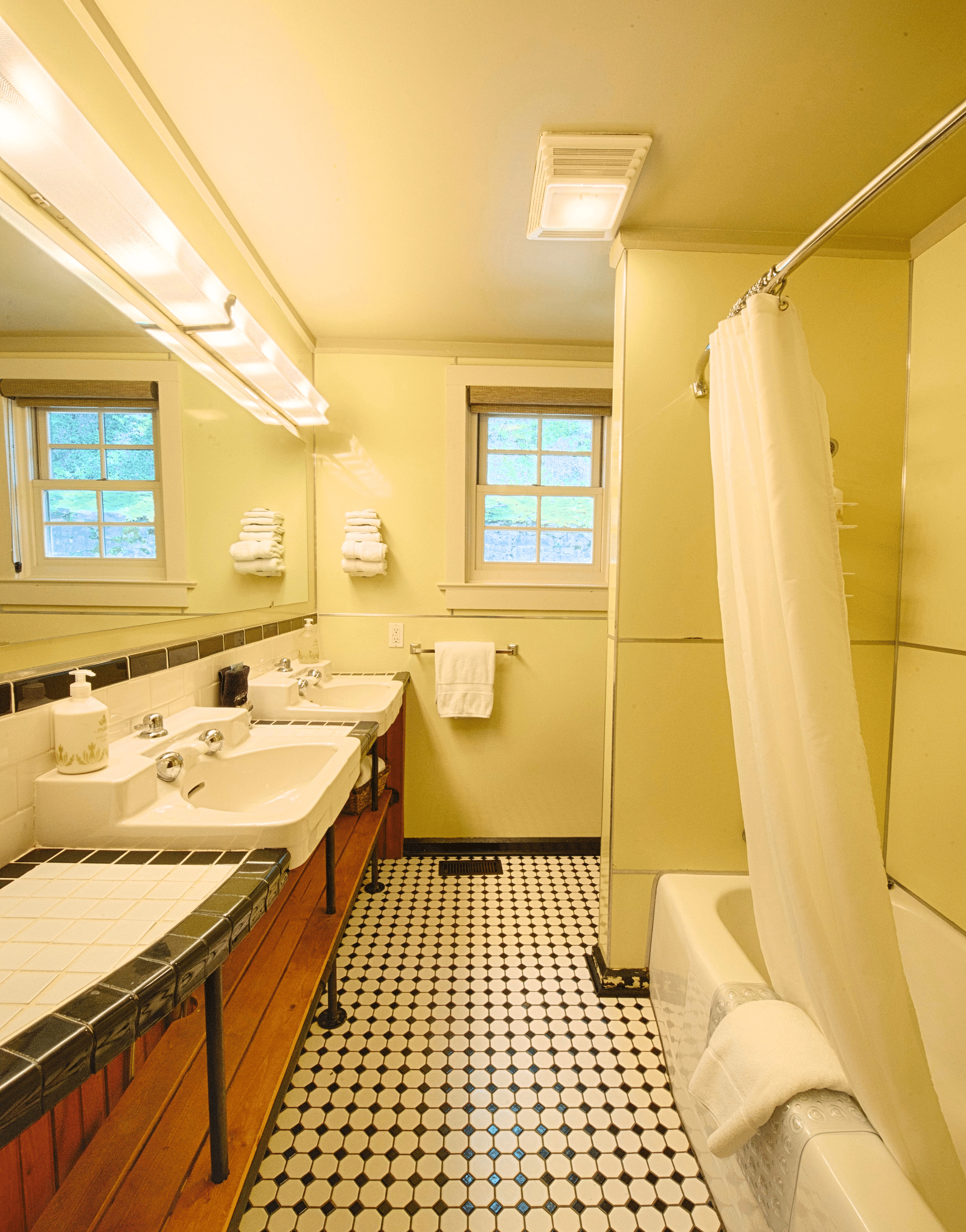 a bathroom with a bath tub and a wash basin placed right opposite to it - Historic Tapoco Lodge