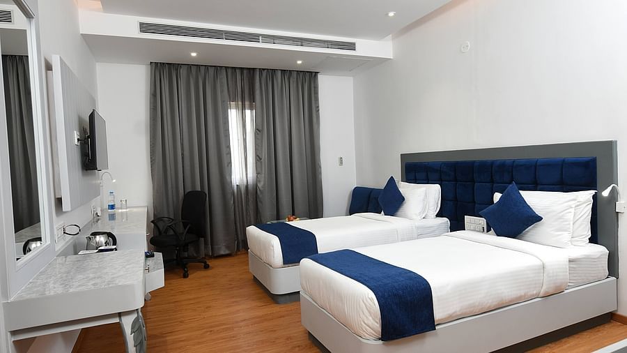 A full view of twin beds with bedding in a spacious room