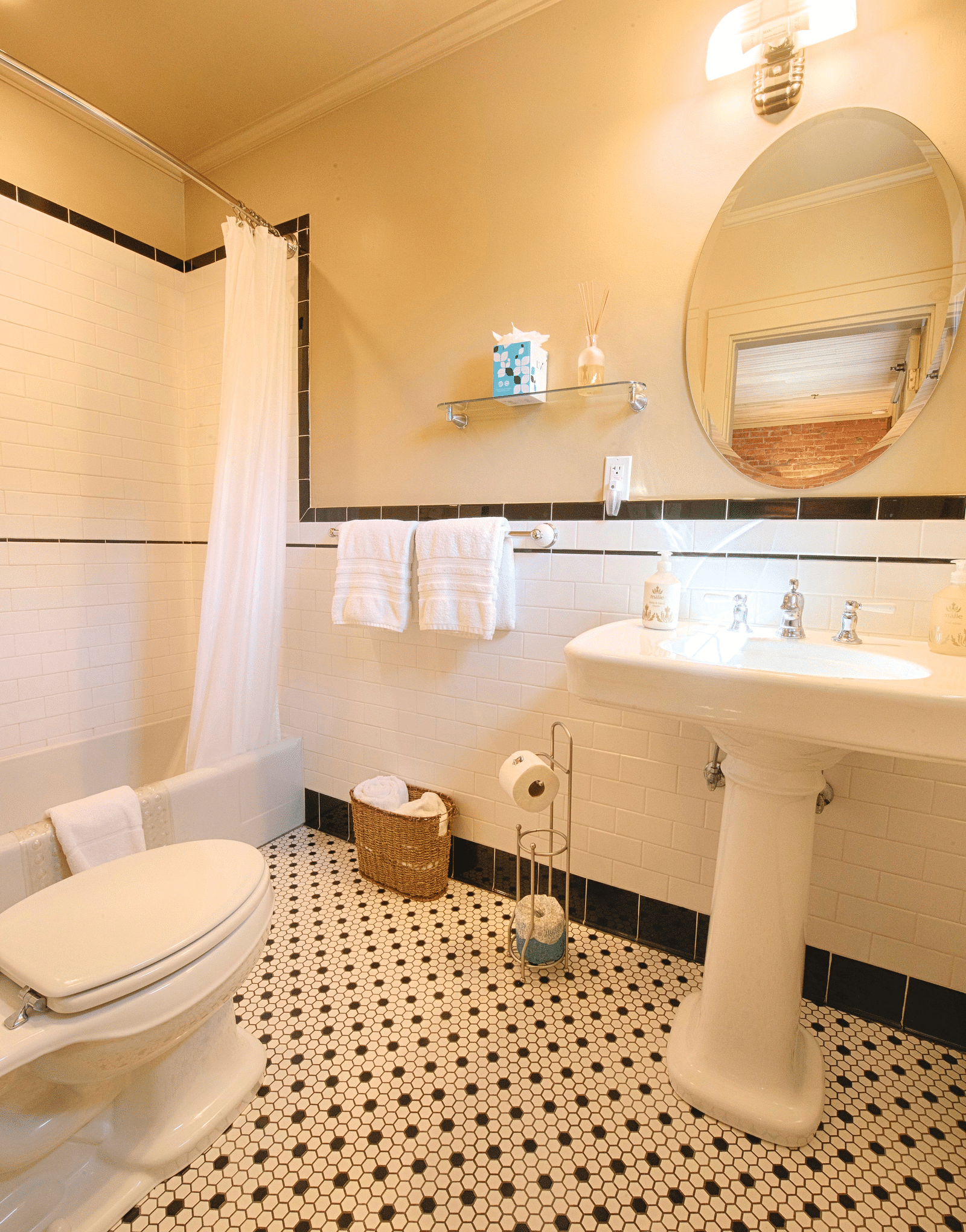 a bathroom featuring a bathtub in the corner along with a washbasin and a commode - Historic Tapoco Lodge