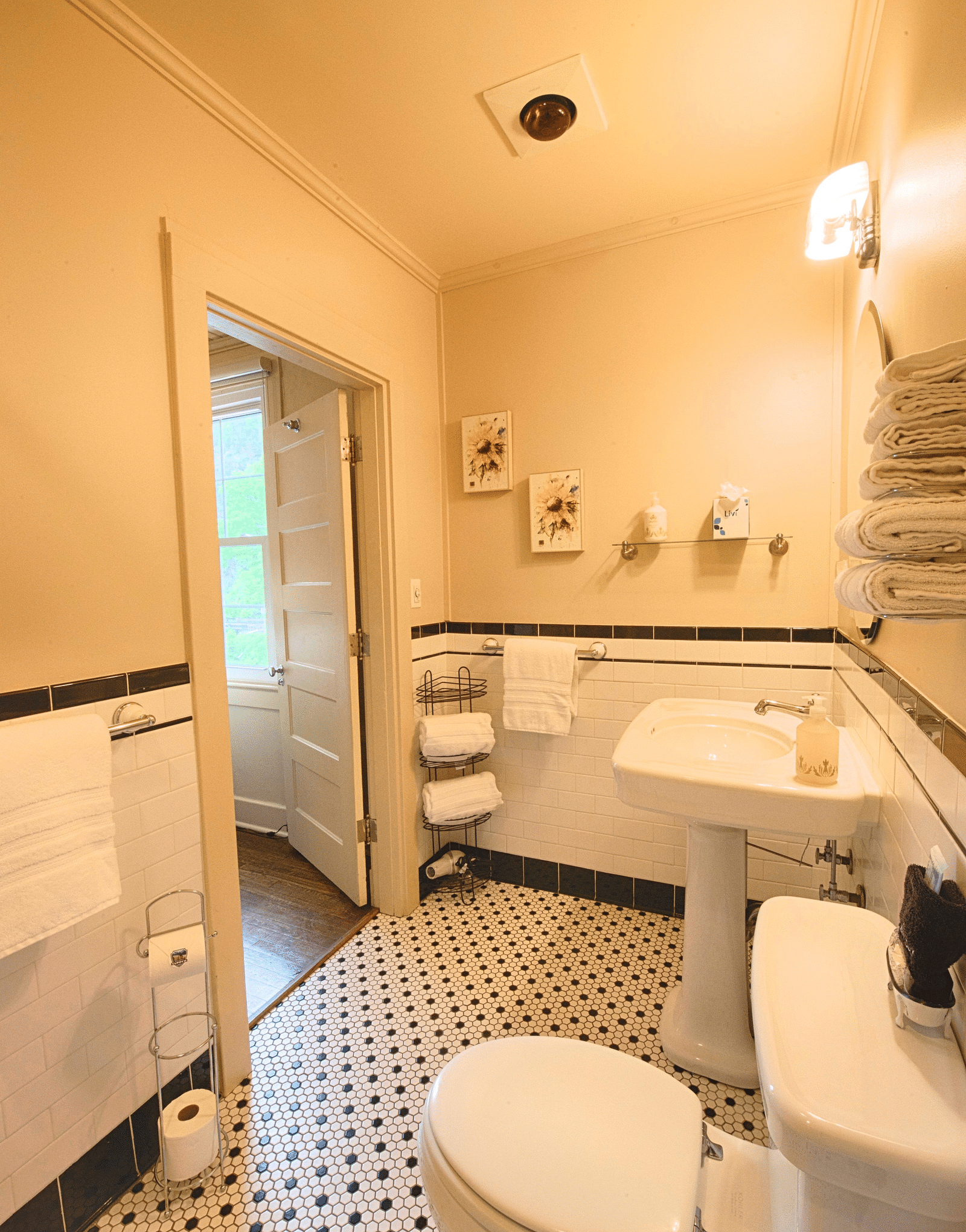 full view image of a compact bathroom with all necessary linens and toiletries and a door opening to the room - Historic Tapoco Lodge