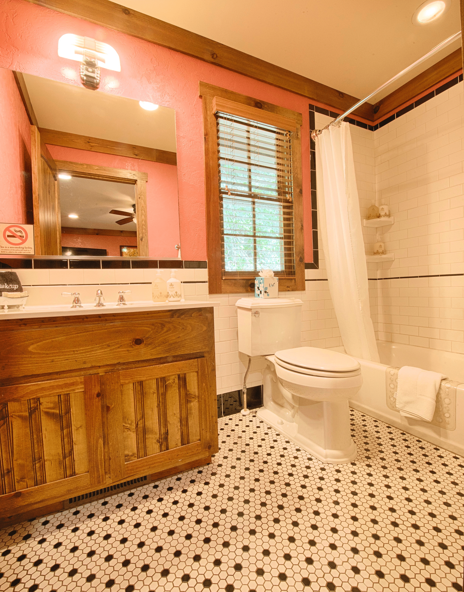a bathroom with ample lighting with a wash basin and a bathtub - Historic Tapoco Lodge