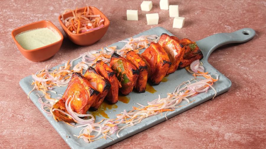 Grilled Paneer Tikka with sauce and salad plated at Monday Hotels Amalapuram Heights.
