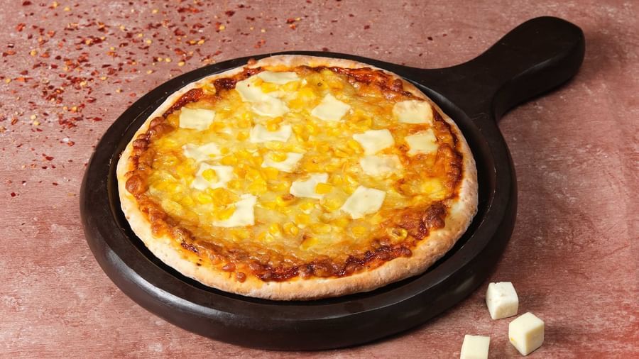 Cheese-loaded Pizza on skillet at Monday Hotels Amalapuram Heights.