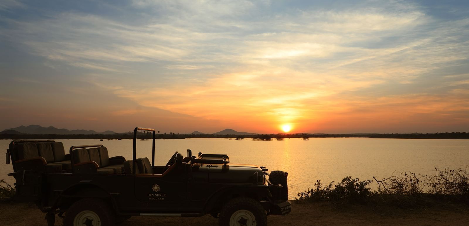 an image of a jeep with sunset in the background at dev shree, deogarh