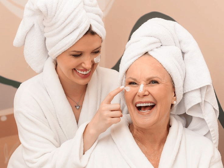 Mother and daughter enjoying a relaxing wellness retreat experience at YO1 Longevity & Health Resorts while wearing white spa robes and towels in a calming spa setting.