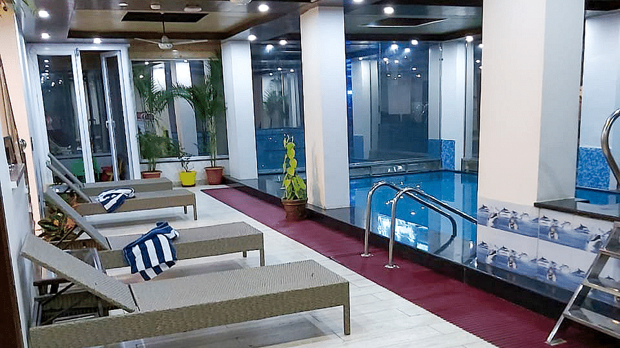 A few sun loungers lined up on the lobby besides the swimming pool at Regenta Inn DLS.