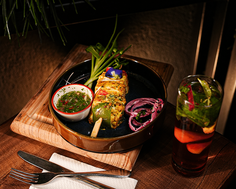 alt-text Wooden tray with sushi rolls, sauces, and refreshing cocktails