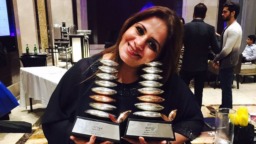 Kiran Bawa posing with two awards - IOSIS Spa & Wellness