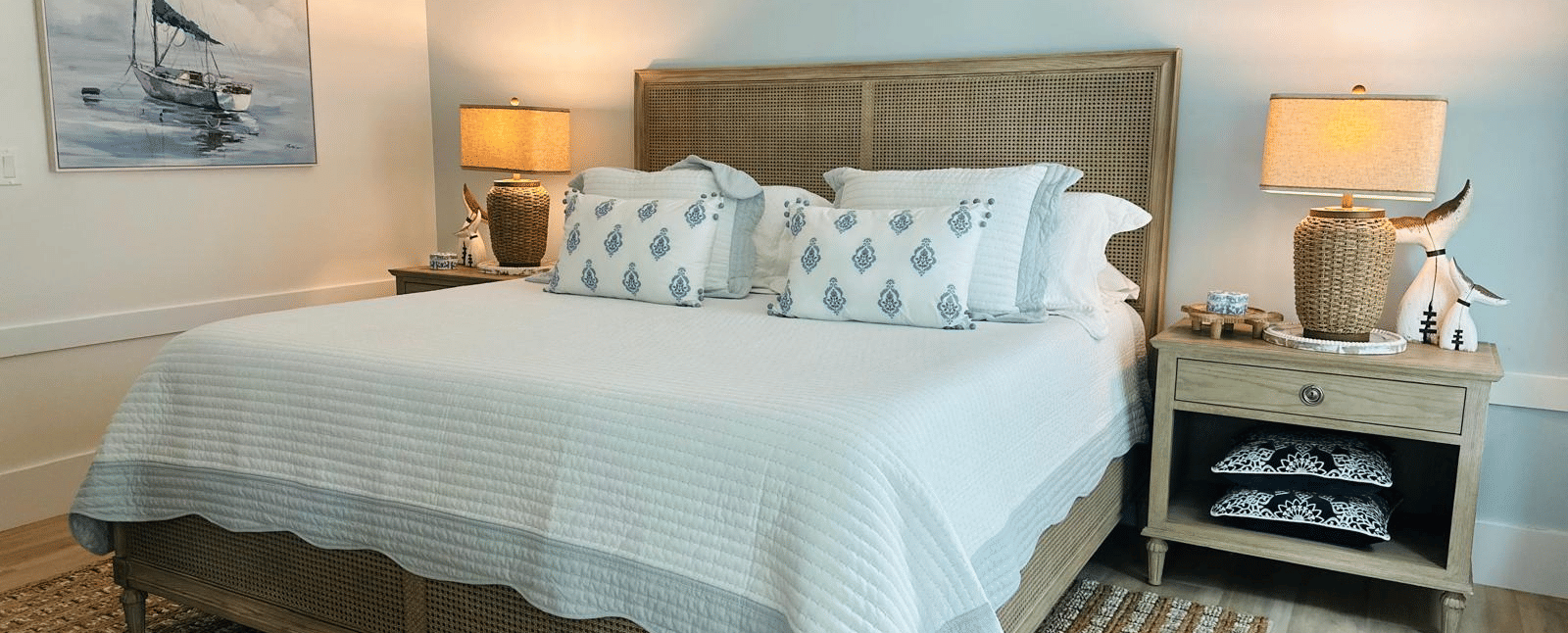 A view of a well made double bed, side tables with lamps and wooden flooring at Elbow Room Villa 7 in  Abaco inn 