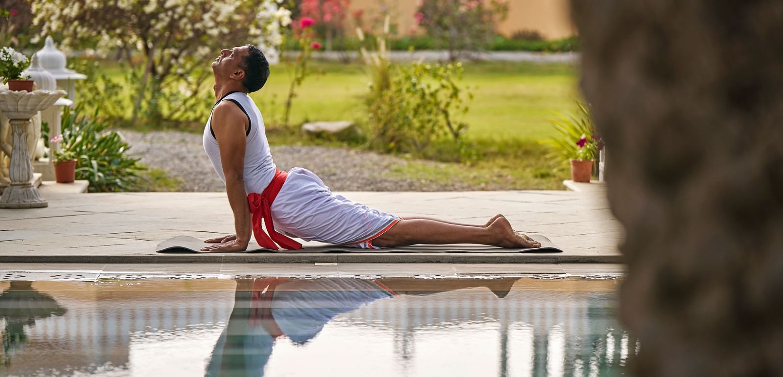 image of a man doing yoga at the poolside at dev shree, deogarh