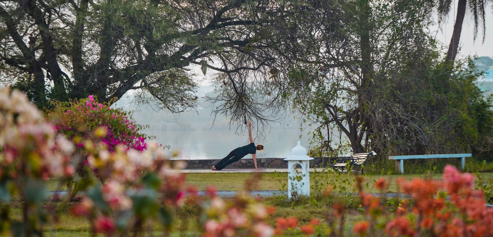 image of a person doing yoga in a garden overlooking bushes of flowers at dev shree, deogarh