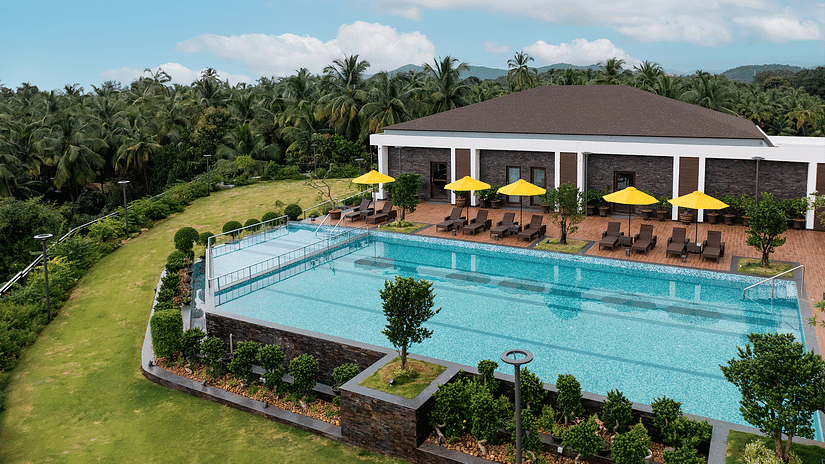 An overhead view of the swimming pool, surrounded by lush plants and greenery, at Cloud9 Sarovar Premiere, Palolem Goa, creates a tranquil, tropical atmosphere