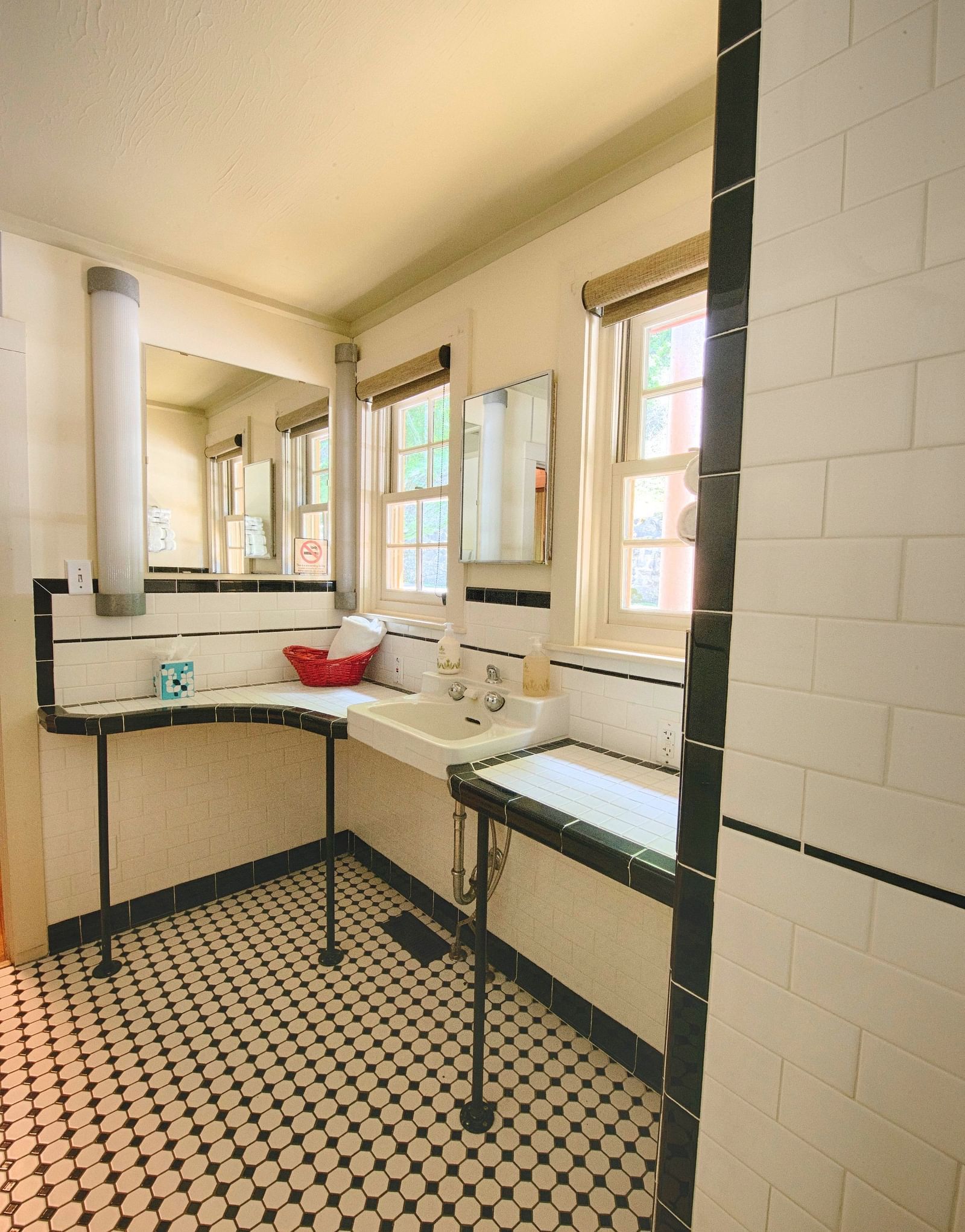 a bathroom with a small counter featuring a small wash basin with two medium sized windows besides it - Historic Tapoco Lodge