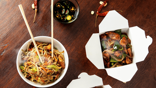 A flat-lay arrangement of Asian noodle portions in square bowls with chopsticks and dried chillies at Bhavanis Vista By Icon Hosur.