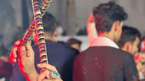 Participants dancing with dandiya sticks in traditional attire outdoors.
