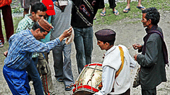 A musician playing the drum and a group of men dancing during Wedding celebration - Ramgarh Bungalows, Nainital.