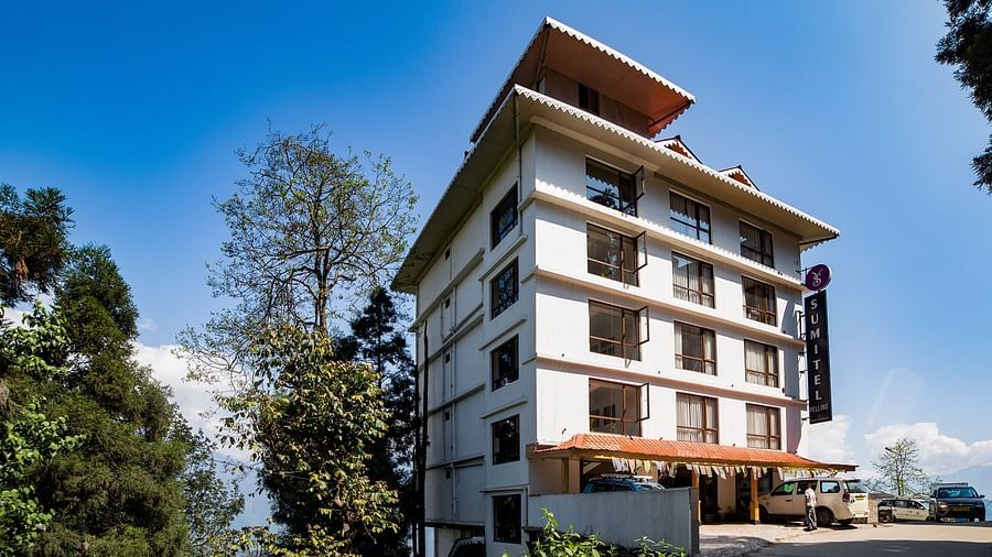 Daytime view of a Sumitel hotel building surrounded by trees and blue sky