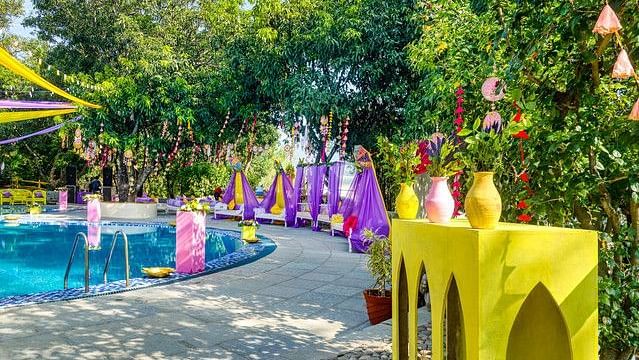 alt-text Festive poolside wedding venue with colorful decorations.