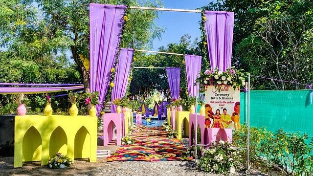 alt-text Festive wedding entrance with floral arch and fairy lights.