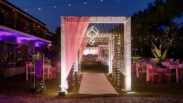 alt-text Festive entrance with floral arch and fairy lights.