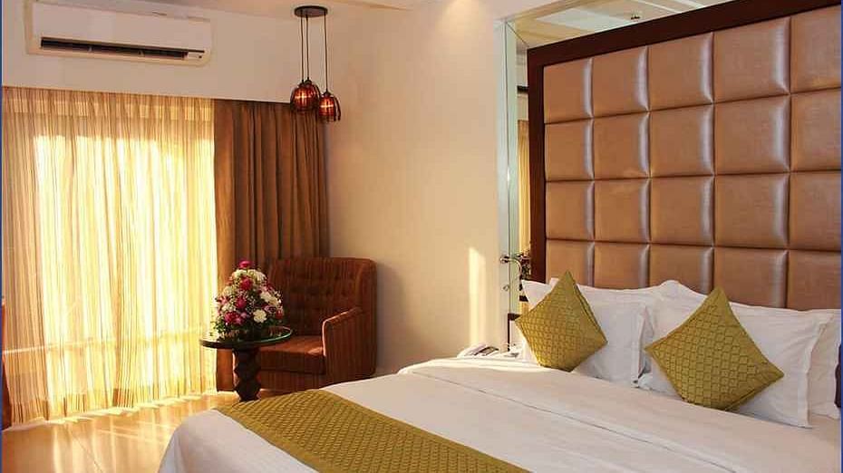 Image of a room with a bed and window on the side at Calux Grand Inn, Calangute.