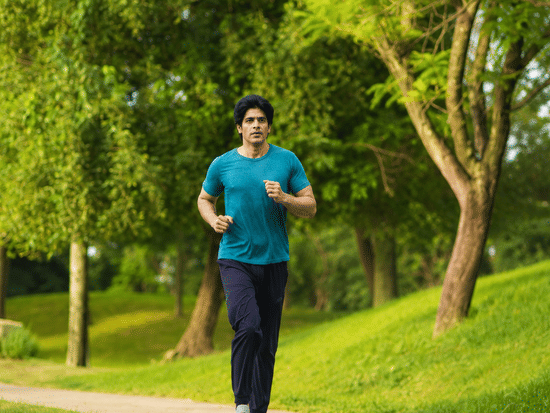 A man jogging in the pathway with trees in the backdrop. | Karma Lakelands