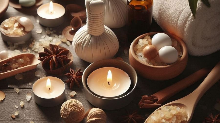 Aromatherapy and Ayurvedic spa setup featuring herbal compresses, essential oils, candles, sea salt, and natural wellness ingredients on a wooden surface.