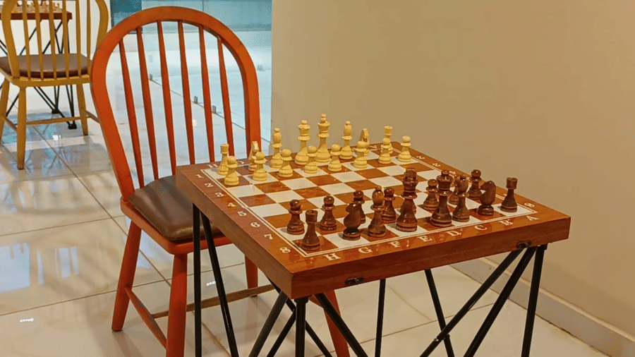 A chessboard is neatly set up on a small wooden table, inviting guests to play in the games area at Vinti Resort, Ambaji.