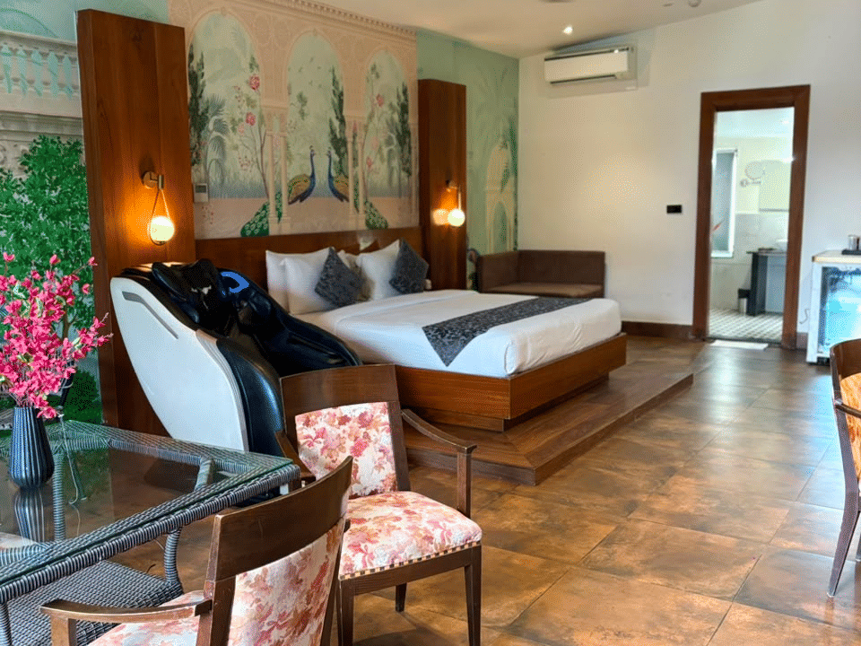 Emperor Room, Massage chair and glass dining table beside the muralled bed