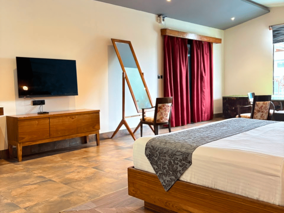 Emperor Room, Wall-mounted television and dresser mirror facing the bed