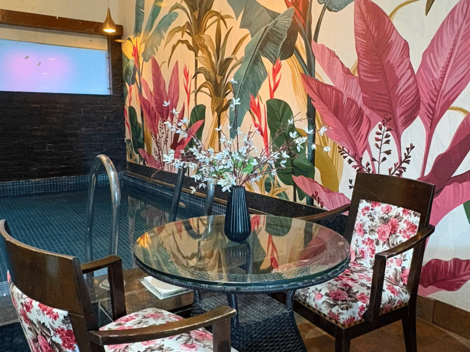King Room, Glass-top table and floral armchairs at the pool edge