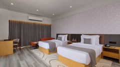 Twin bedroom with contemporary decor and patterned carpet - Pride Elite Gandhinagar