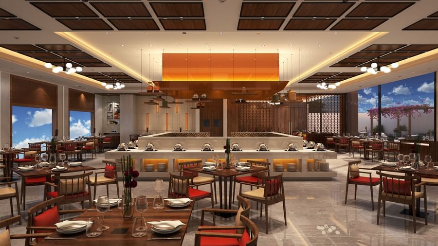 A spacious dining area interior with numerous tables and chairs set up for patrons | Sarovar Portico, Hanumangarh