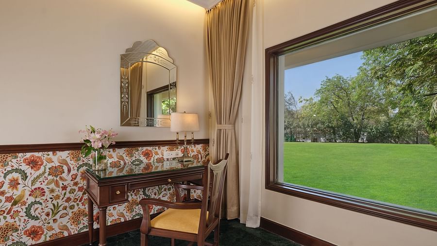 The Premium King Garden View Room at The Ummed Ahmedabad includes a well-placed work desk by the window, overlooking lush gardens