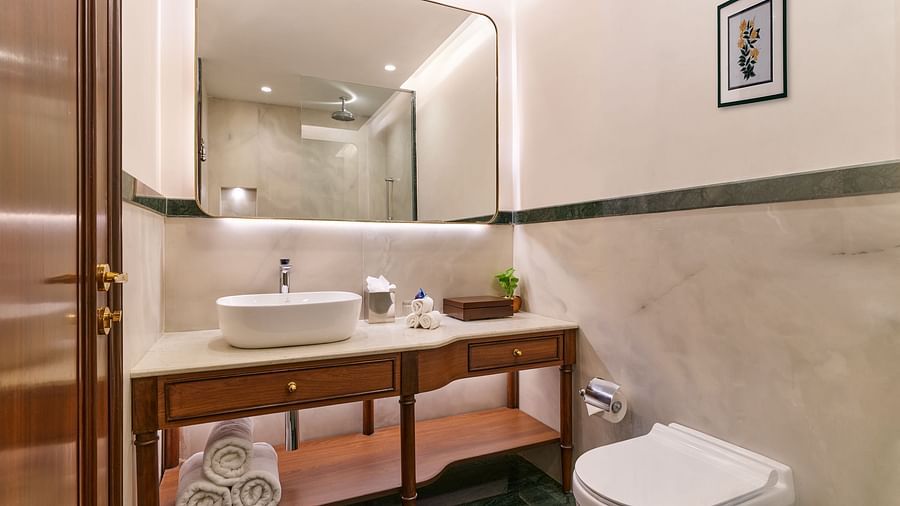The Premium King Garden View Room at The Ummed Ahmedabad has a modern bathroom with a sleek vanity, fresh towels, and essential toiletries