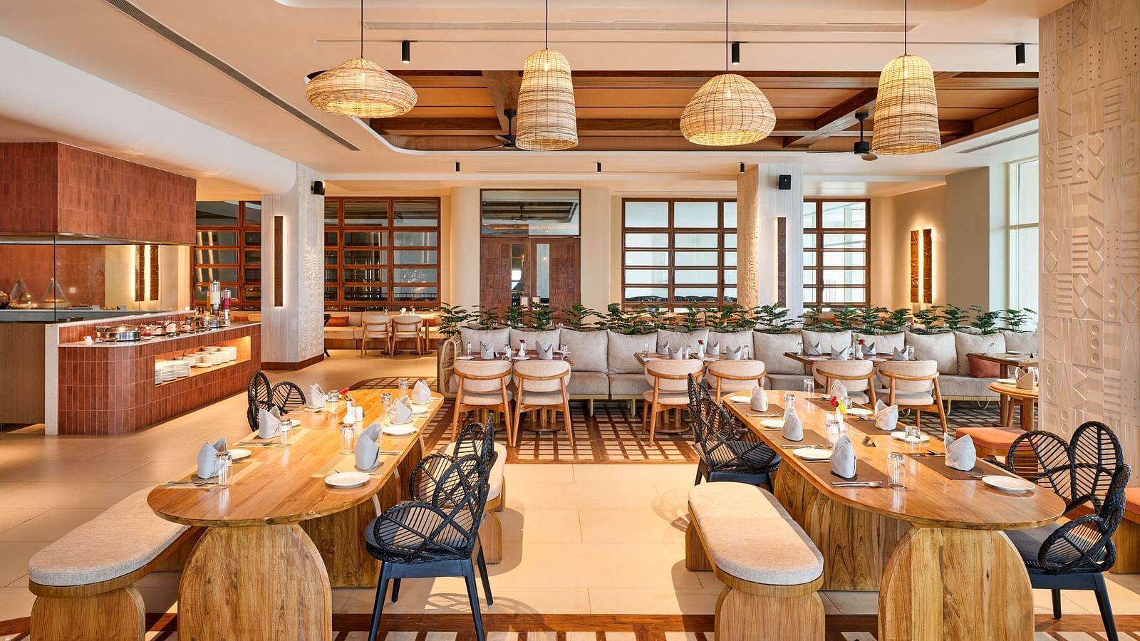 Image of Beach Hut Restaurant at Swosti Premium Beach Resorts in Puri featuring extensive sitting area including sofas and chairs and wooden tables